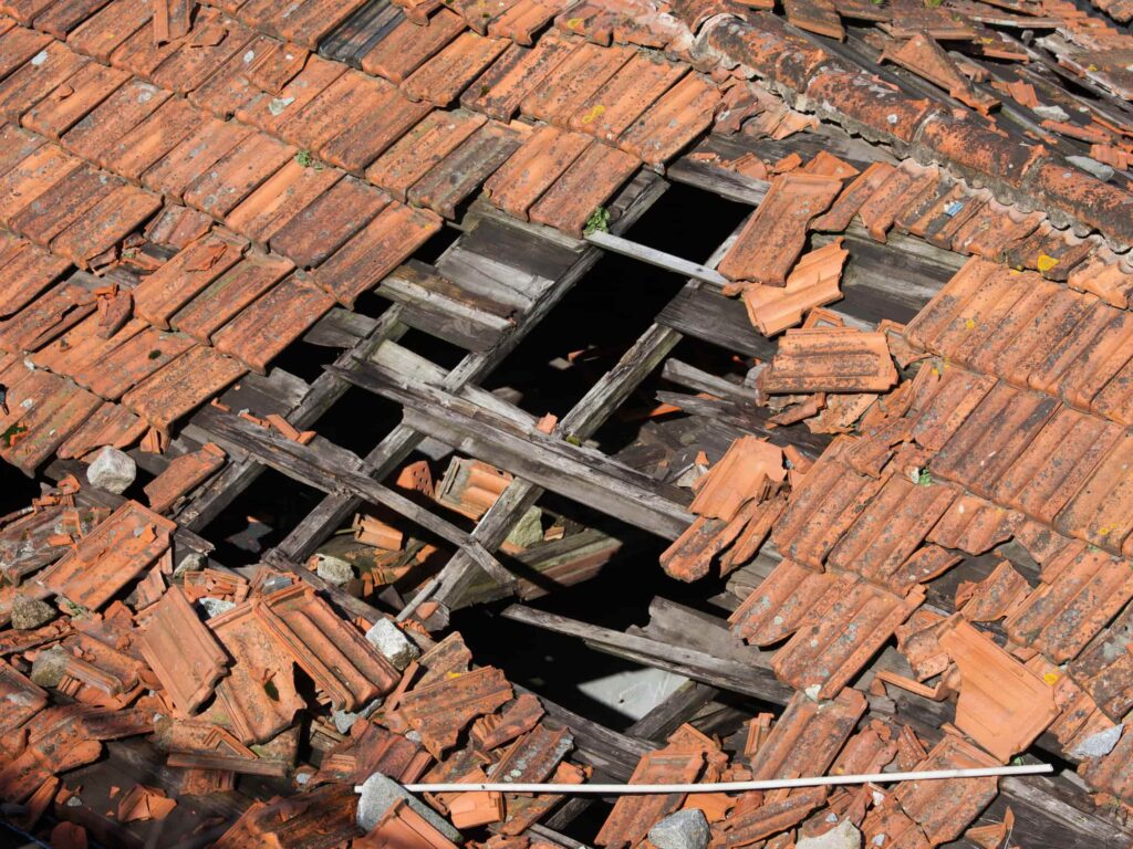 Collapsed roofs exposing wooden timber frames needing complete roof restoration